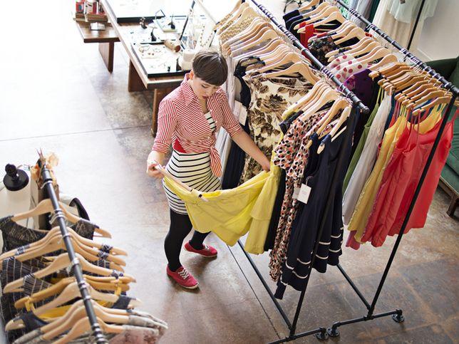 kobieta stojąca przy ubraniach w sklepie